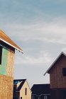 Обрізаний вид дахів будинків на блакитне небо на дачній ділянці . — стокове фото