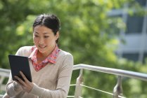 Mitte erwachsene Frau nutzt digitales Tablet im Stadtpark. — Stockfoto