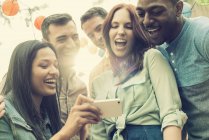 Group of cheerful friends gathering and taking group selfie. — Stock Photo