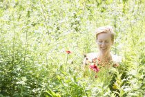 Woman among dense meadow of flowers at commercial nursery. — Stock Photo