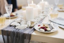 Table servie pour le repas de célébration avec verres à vin et assiettes de fruits — Photo de stock