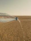 Wasser, das aus der Flasche in die Landschaft der schwarzen Felswüste in Nevada strömt — Stockfoto