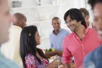 Man and woman at center of group of friends at indoor party. — Stock Photo