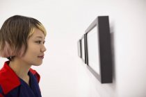Close-up of young woman looking at artwork in studio. — Stock Photo