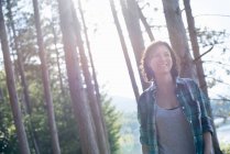 Mitte erwachsene Frau spaziert im Sommer durch Wald. — Stockfoto