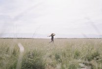 Женщина, бегущая по траве на лугу
. — стоковое фото