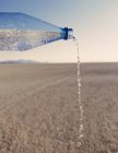 Eau coulant de la bouteille dans le paysage du désert de Black Rock dans le Nevada — Photo de stock