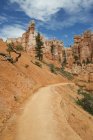 Sandstone pillars and road through desert of Bryce Canyon in USA. — Stock Photo