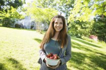Femme portant un bol de fraises fraîches biologiques . — Photo de stock