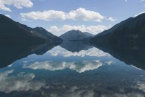 Mirror reflection of sky and clouds in Lake Crescent, Washington, USA — Stock Photo