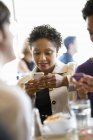 Les femmes vérifient les téléphones mobiles lors d'une réunion avec des amis au restaurant . — Photo de stock