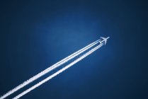 White jet vapor trail across blue sky. — Stock Photo