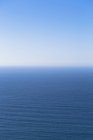 Oceano Pacifico acque calme che si fondono nel cielo blu
. — Foto stock