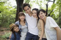 Grupo de amigos japoneses posando y abrazándose en el bosque . - foto de stock