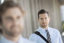 Two businessmen standing on street with focus on background. — Stock Photo