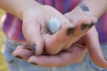Крупним планом жіночі руки тримають маленьке блакитне пташине яйце . — стокове фото