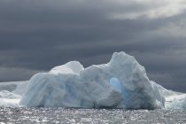 Eisberg auf dem Wasser des Südlichen Ozeans unter stürmischem grauen Himmel. — Stockfoto