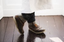 Крупним планом чоловічі ноги в коричневому взутті з помаранчевими шнурками взуття . — стокове фото