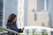 Деловая женщина в сером костюме с помощью смартфона в центре города . — стоковое фото