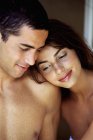 Joven hombre y mujer en topless sonriendo y abrazándose en el interior . - foto de stock