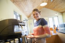Junge Frau kocht Kaffee mit großer Kaffeemaschine. — Stockfoto