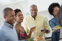 Small group of people holding drinks at indoor party. — Stock Photo