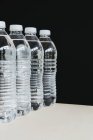 Рядок прозорих пластикових пляшок води, наповнених фільтрованою водою . — стокове фото