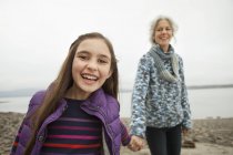 Mature woman holding hands with pre-adolescent girl. — Stock Photo