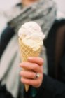 Primo piano del gelato nel cono di cialde in mano alla donna . — Foto stock