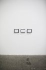 Três molduras na parede branca no estúdio de arte . — Fotografia de Stock