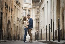 Mid adult couple standing and looking at each other in narrow street in city. — Stock Photo