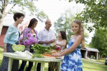 Réunion de famille autour de la table et préparation de légumes et fruits frais . — Photo de stock