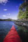 Bow of red canoe boat floating on river water in Alaska. — Stock Photo