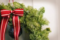 Christmas wreath with red bow on front door of house, close-up. — Stock Photo
