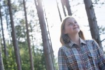 Pre-adolescent girl walking in woodland in summer. — Stock Photo