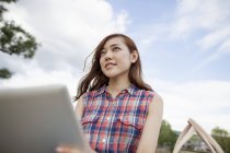 Низький кут зору молодої жінки з цифровим планшетом в парку . — стокове фото