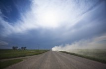 Truck raising dust while riding on prairie road. — Stock Photo