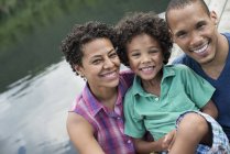 Портрет щасливих батьків та хлопчика початкового віку біля озера влітку . — стокове фото