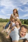 Father and mother with children playing in park. — Stock Photo