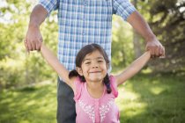 Father holding hands with elementary age daughter in park. — Stock Photo