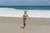 Menina adolescente feliz correndo na praia do mar . — Fotografia de Stock