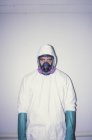 Man in white protective clean suit, blue gloves and breathing mask. — Stock Photo