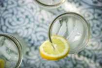 Вид зверху на лимонадні окуляри зі свіжим шматочком лимона . — стокове фото