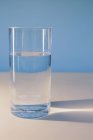 Bicchiere di acqua filtrata su superficie bianca . — Foto stock