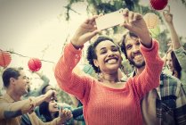 Cheerful woman and man taking selfie at dancing party outdoors. — Stock Photo