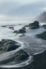 Formación rocosa en la costa con playa de arena en marea baja, Parque Nacional Olímpico, EE.UU. - foto de stock