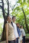 Gruppe asiatischer Freunde steht in einer Reihe im grünen Wald. — Stockfoto