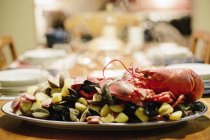 Plato de mariscos con langosta y almejas en mesa servida . - foto de stock