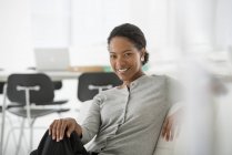 Жінка розслабляється на зручному кріслі в сучасному офісному інтер'єрі . — стокове фото