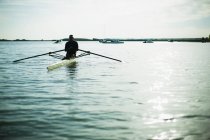 Visão traseira do homem em barco a remo na água do lago . — Fotografia de Stock